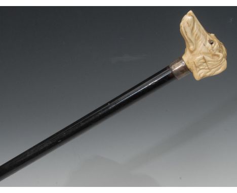 A late 19th century walking stick, the ivory handle carved with a hound, glass eyes, silver collar, ebonised shaft, 91cm high