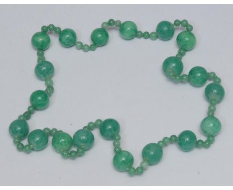 A green glass jade effect bead necklace, large irregular globular beads each divided by a trilogy of smaller conforming beads
