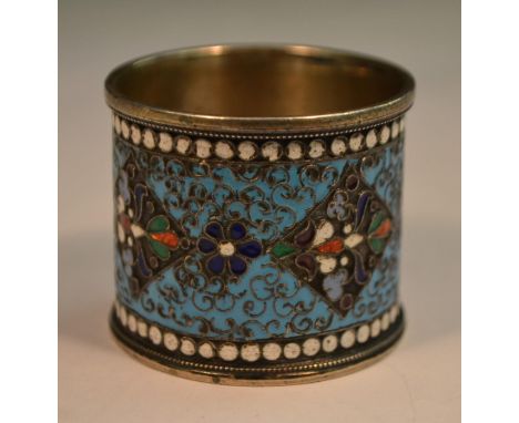 A Russian silver and cloisonne enamel napkin ring, brightly decorated in polychrome, white 'jewelled' border, 4cm long, c.190