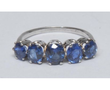 A sapphire quintet ring, liner set with five graduated vibrant blue oval and round cut sapphires, total estimated sapphire we