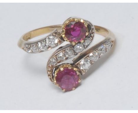A ruby and diamond cluster ring, snaking crest inset with two pinkt red rubies and thirteen old cut diamonds, total estimated