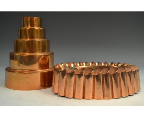 A 19th century copper fluted oval 'ring' jelly mould, 21cm wide; a 19th century circular graduated 'tower' jelly mould, 17cm 