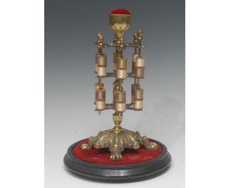 A Victorian brass two tier cotton reel stand,  pin cushion finial, the base cast with acanthus leaves, paw feet, under a dome