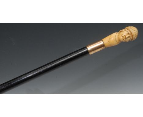 A late 19th century walking stick, the ivory handle carved with a Wagnerian man, gilt metal collar, ebonised shaft, 87cm long