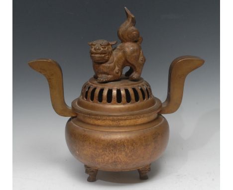 A Japanese gilt bronze koro, domed cover with cast temple lion finial, S-shaped lug handles, lion mask feet, 34cm wide, early