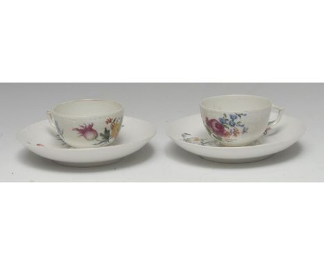 Two  18th century Berlin teacups and saucers, painted with colourful flowers below an ozier moulded border, septre marks