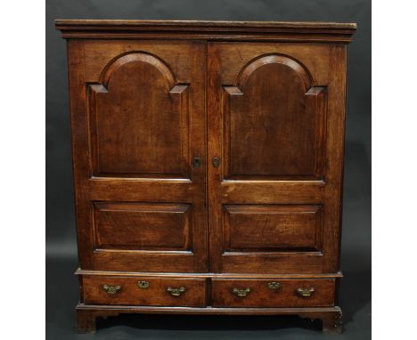 A 'George III' oak low press/housekeeper's cupboard, moulded cornice above a pair of raised and fielded arched panel doors, t