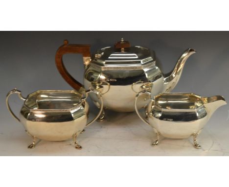 A George V silver three piece tea service, comprising teapot, milk jug and sugar basin, the teapot with bakelite fittings, 26
