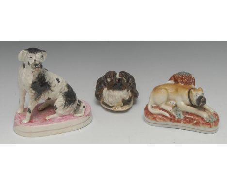 A Staffordshire model, of a seated hound, with black patch markings, oval base, washed in pink, 16cm high, c.1850;  a Staffor