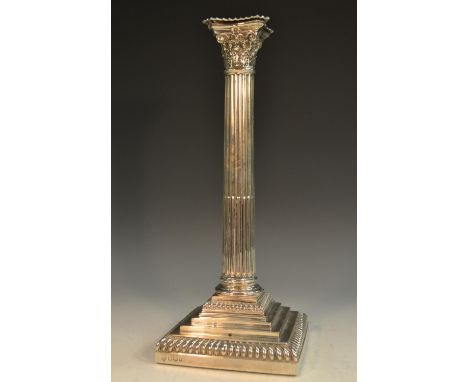 An Edwardian silver Corinthian column table candlestick, of George III design, detachable nozzle, stop-fluted pillar, stepped