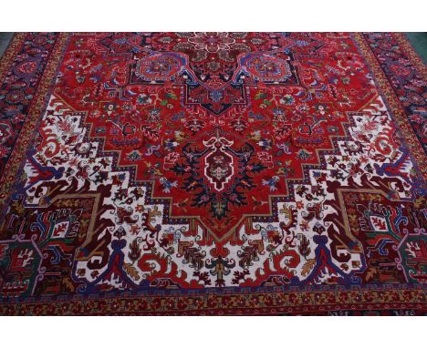 A large rectangular woollen carpet, colourfully worked in the typical Middle Eastern manner with hooked medallions, stylised 