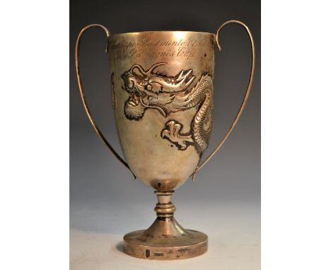 A Chinese silver presentation cup, repousse chased with a ferocious dragon, scroll handles, domed circular foot, 18cm high, W