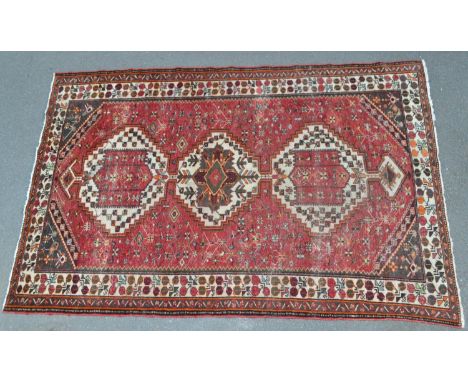 A Persian Hamandan woollen carpet, in tones of red, cream and green, 317cm x 207cm