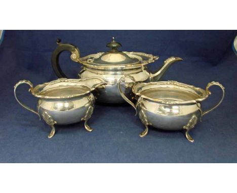 An early 20th century silver three-piece Tea Service of compressed oval shape, shaped edge with cast decoration, each piece w