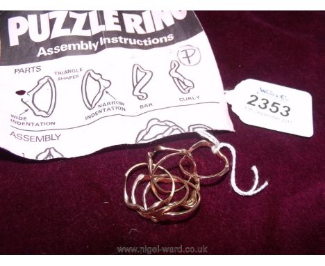 A 9ct gold puzzle ring (with instructions)