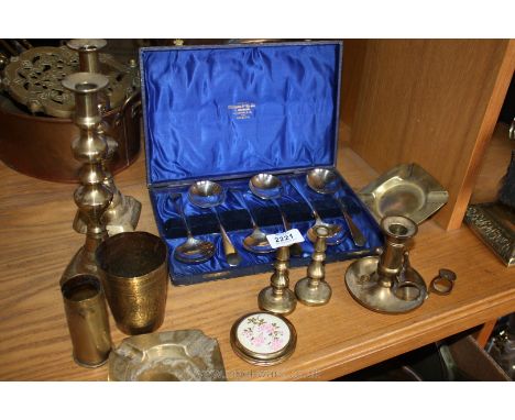 Two large brass candlesticks, ashtrays, a chamber stick, small candlesticks, a beaker, a small shell case and a cased set of 