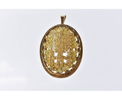 A South American yellow metal pendant cum brooch, the oval mount marked 18k, with pierced and chased ancient Inca style desig