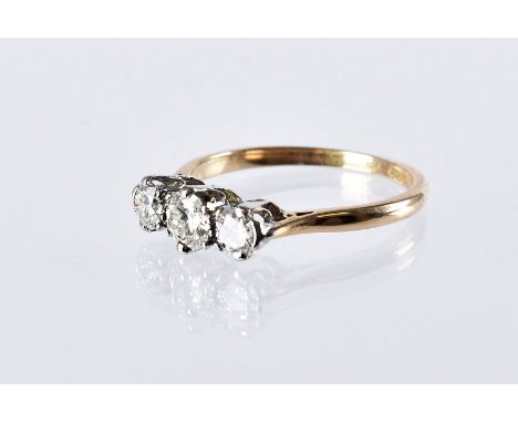 An Art Deco period three stone diamond engagement ring, three brilliant cuts in platinum set, on an 18ct gold band, 2.7g and 