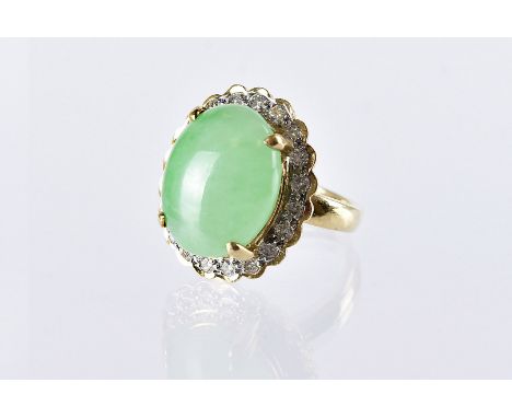 A modern Chinese hardstone and diamond dress ring, in yellow metal mount marked 18k, large green jade style stone with brilli