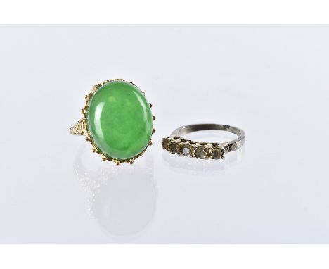 A 1970s Chinese hardstone cocktail dress ring, the yellow metal mount with a large green jadeite cabochon stone, now glued in