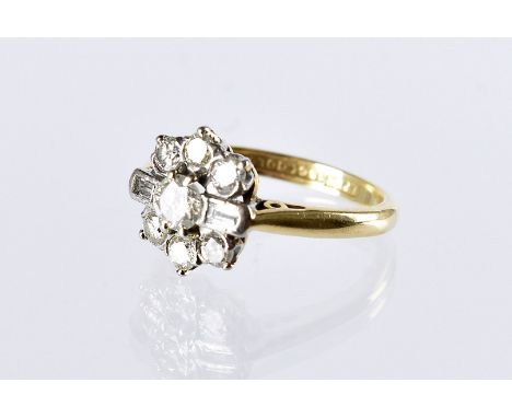 An Art Deco diamond cluster ring, the flower head tablet centred with a brilliant cut flanked by a baguette cut and further b