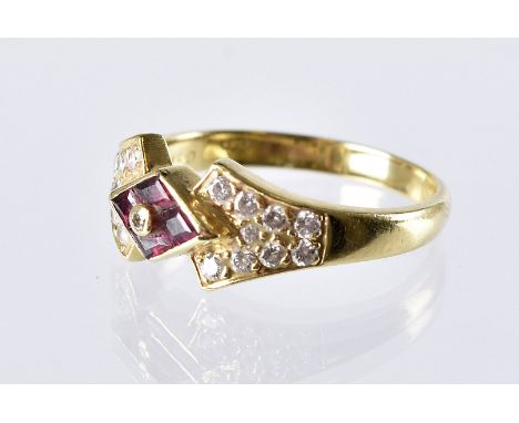 A modern 18ct gold ruby and diamond ring, diamond shaped tablet set with four red stones and a central brilliant cut and havi