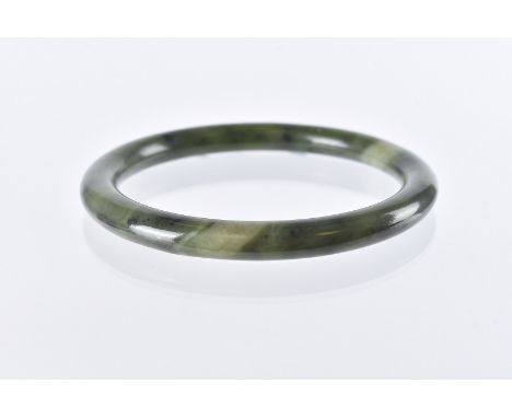 A Chinese hardstone bangle, circular in spinach jade, 7.9cm outer diameter and 6.1cm inner diameter 
