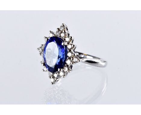 A modern tanzanite and diamond cluster cocktail dress ring, the Rhapsody platinum mount having a large central blue stone of 