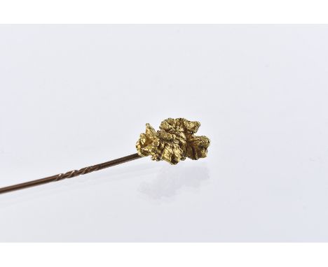 An Edwardian period gold nugget stick pin, the piece of gold ore attached by wire to a gold pin, 7.3g 