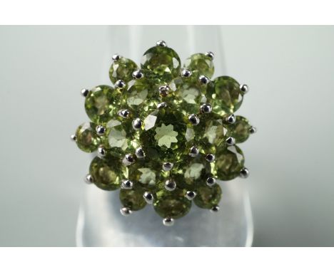 A contemporary demantoid dress ring, in a tiered arrangement, on a white metal shank, tested as silver, size R 1/2, 5.9g