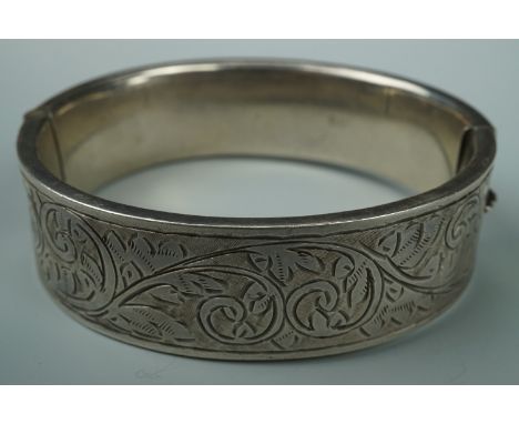 A 1950s engraved silver hinged bangle, 6 cm x 5.5 cm internally