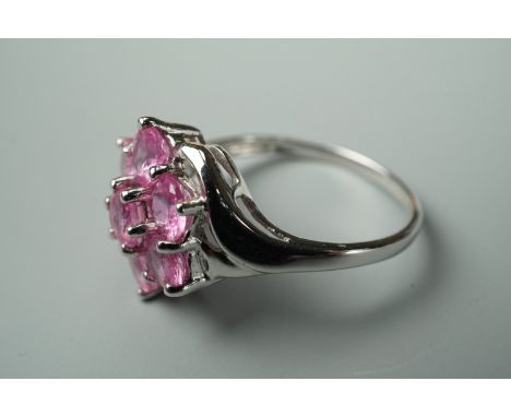 A contemporary pink sapphire and 9ct white gold dress ring, in a flower head cluster setting, size O, with certificate of aut