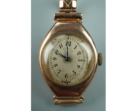 A 1920s lady's 9 ct gold wristlet watch, having a Bird-in-Ring movement and elliptical face within an exaggerated tonneau sha