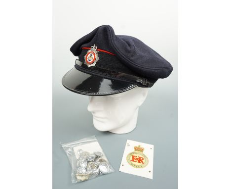 A Ministry of Defence Fire Service peaked cap together with related insignia including an Army Fire Service helmet decal