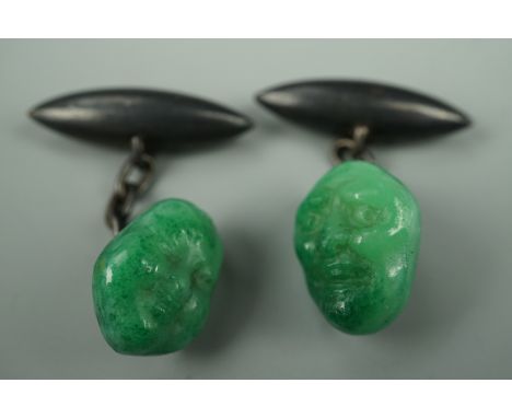 A pair of 1920s faux jade and silver cuff links, modelled as Japanese noh masks with silver torpedo backs