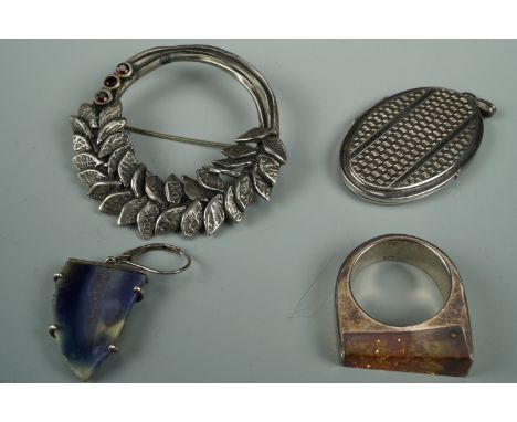 A white metal oval double pendant locket, each face decorated with engine turning, together with a large white metal annular 