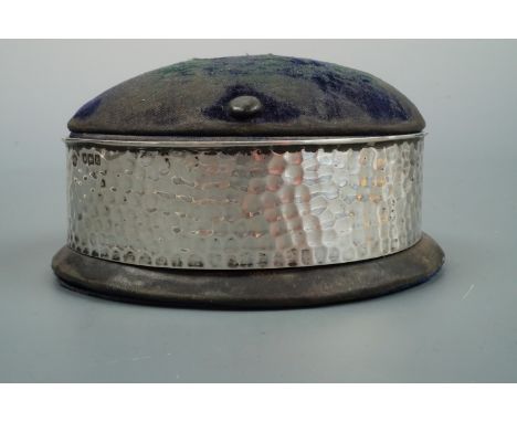 An Edwardian Arts and Crafts influenced silver mounted ring box / hat pin cushion, William Comyns, London, 1903, 12 x 10 x 6.
