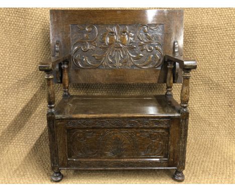 An old reproduction carved oak monk's bench