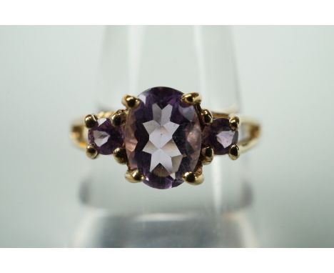 A contemporary three-stone amethyst dress ring, on 9ct gold, size N 1/2, with certificate of authenticity, 3.1g