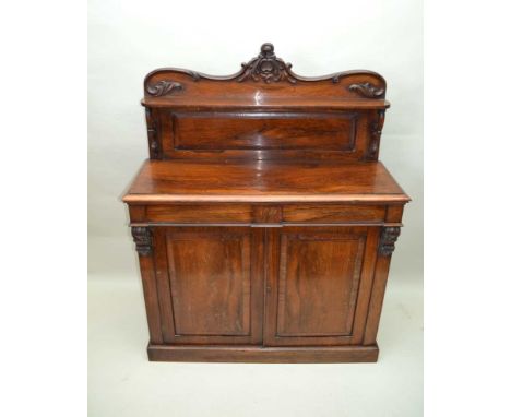 A 19TH CENTURY ROSEWOOD CHIFFONIER, with shaped single panelled upstand with display shelf, the base unit having two inline c