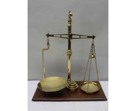 A 19TH CENTURY POLISHED BRASS SET OF BALANCE SCALES supported on a rectangular wooden plinth base, together with a selection 