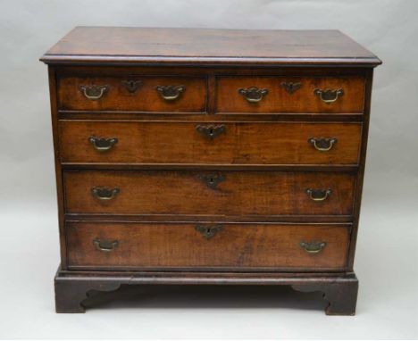 A 19TH CENTURY OAK CHEST OF DRAWERS, having rectangular plank top over two inline and three graduating full width drawers, wi