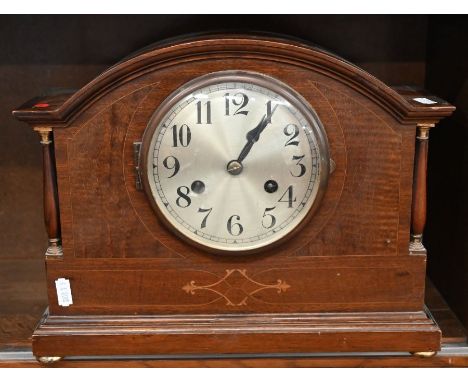A German inlaid mahogany twin-train mantle clock with silvered dial, striking on a coiled gong, 33 cm wide