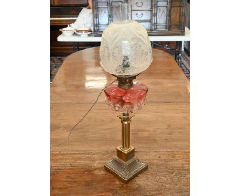 A Victorian oil lamp with etched glass shade and cranberry font, on brass pillar base (converted to electricity) to/w an Indi