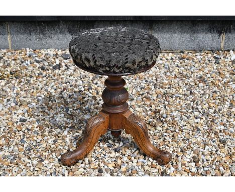 A Victorian revolving piano stool on tripod base