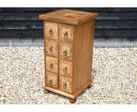 A Barker and Stonehouse&nbsp; mango-wood eight drawer apothecary chest with flagstone tile inlays and starburst ring handles,