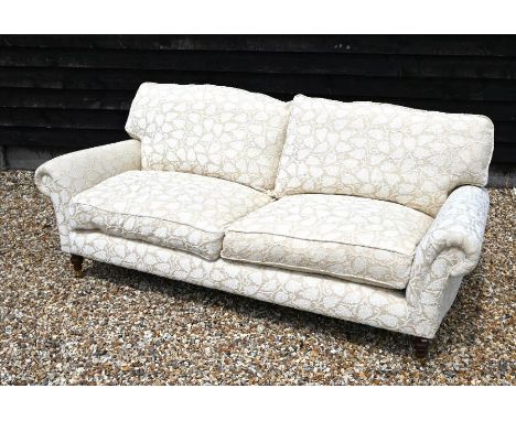 'Highly Sprung Limited' Howard style three seater sofa, cream and beige foliate upholstery on turned mahogany front supports 