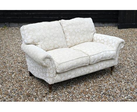'Highly Sprung Limited' Howard style two seater sofa, cream and beige foliate upholstery on turned mahogany front supports wi