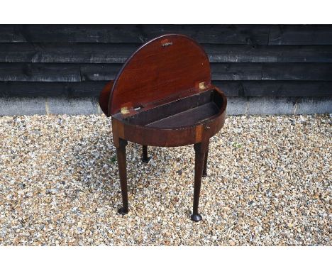 A George III mahogany demi-lune tea table with twin hinged folding top revealing a storage well, raised on a turned and pad-f