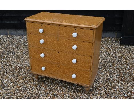 A Victorian scumbled pine chest of two short over three long drawers with cream ceramic handles, raised on short turned suppo